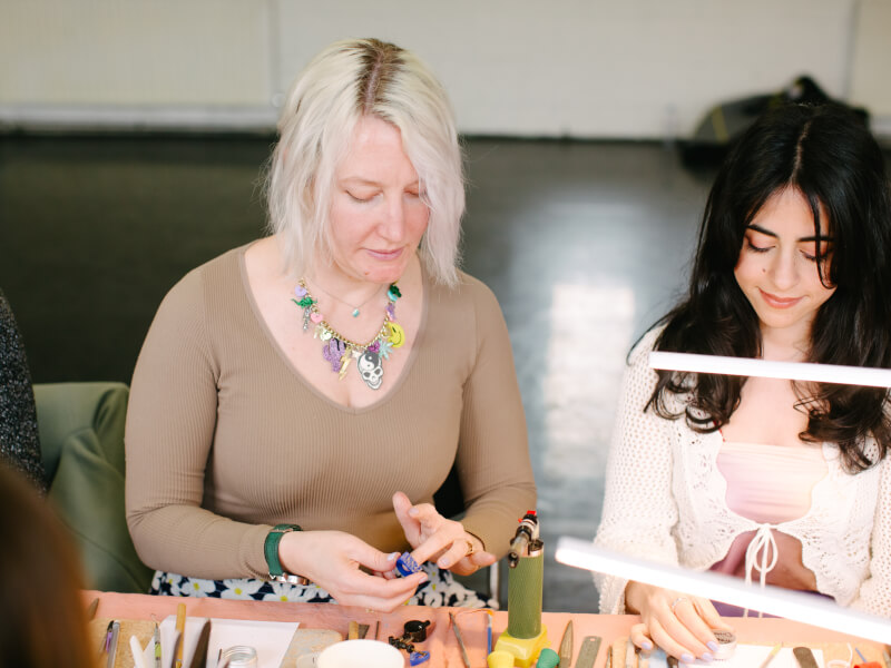 Two women working together at a ring making class